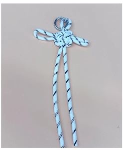 Macro shot of hand-woven white knot pendant with silver metal ring and cord details