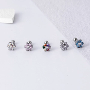 Detailed macro view of five colorful zircon flower cartilage earrings with screw ball backs