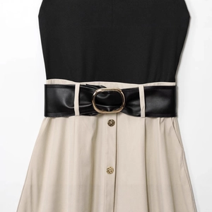 Robe ajustée contrastée avec col montant, haut noir, jupe beige et ceinture à la taille