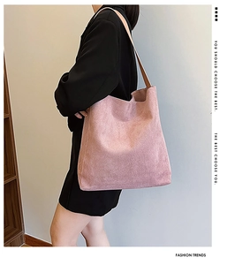 Borsa tote rosa satinata indossata da una modella, che mostra la texture e la tracolla