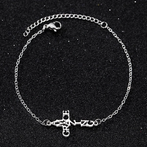 Detail of silver stainless steel cross bracelet with GRACE lettering and lobster clasp