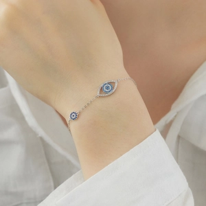 Bracelet œil porte-bonheur en argent S925 et zircons porté sur un poignet