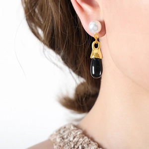 Elegant pearl and black teardrop earrings featuring a polished gold metal finish