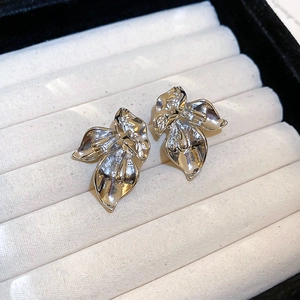 Close-up of vintage flower stud earrings in silver metal on a soft jewelry box display