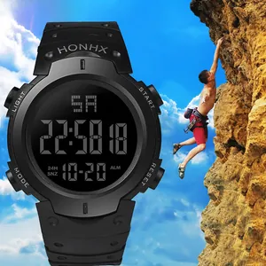 Detail view of large digital sport watch display with outdoor rock climbing background