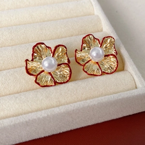 Detailansicht der roten Blumenohrringe mit Goldblättern und Perlen in einer Schmuckbox