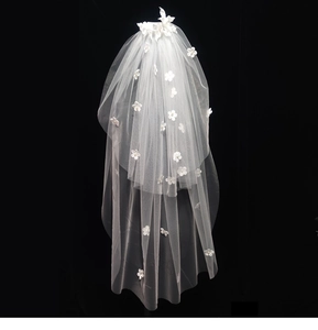 Detail of white bridal veil with 3D floral lace and pearls on black background