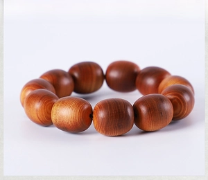 Close-up of polished Thuja wood prayer beads with natural cloud grain texture