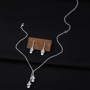 Silver flower wedding necklace and drop earrings set with crystals on black background