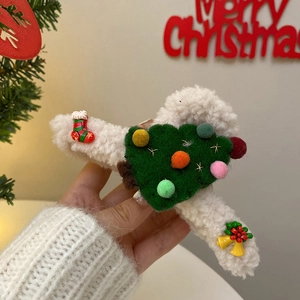 Detail of Christmas claw clip with green felt tree, red socks, and golden bell ornaments