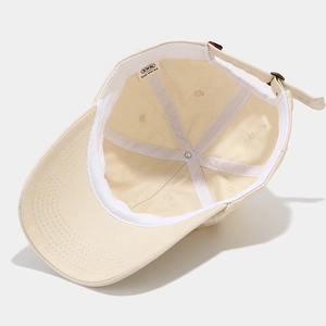Beige cotton baseball cap interior detail showing sweatband and adjustable metal buckle