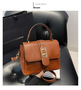 Close-up of brown PU leather handbag with gold oval clasp on a minimalist background
