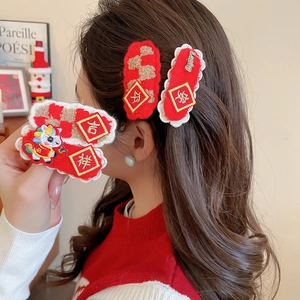 Detail of red Chinese New Year hair clip with Lucky metal charm and embroidery