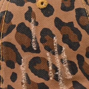 Macro detail of leopard print canvas baseball cap with distressed texture and yellow eyelet