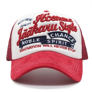 Detailed view of high-density 3D embroidery on breathable red and white mesh trucker hat
