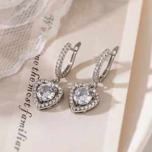 Macro view of silver heart earrings with sparkling cubic zirconia and intricate metalwork