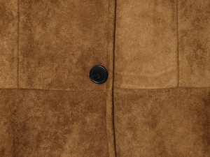 Close-up of brown faux suede fabric texture with a black four-hole button detail