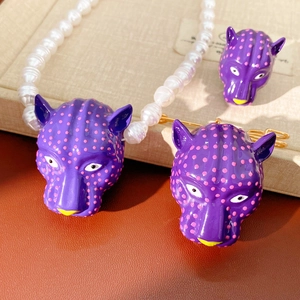 Vue détaillée de la parure de bijoux tête de léopard violette avec collier et broche