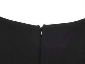 Close-up of the smooth black fabric and hidden back zipper detail on the sleeveless top