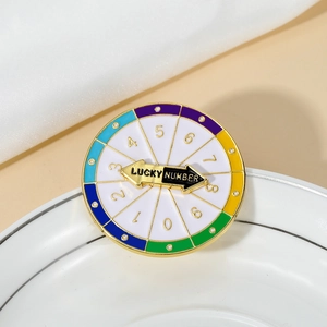 Détail d'une broche en émail coloré avec cadran de numéros chanceux et aiguille noire