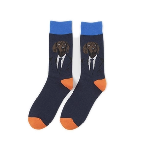 Close-up of navy crew socks with dog in suit pattern and contrast orange heel and toe