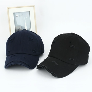 Detail of distressed cotton baseball caps in black and navy showing ripped worn effects