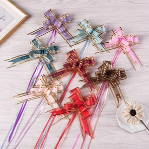 Close-up of colorful matte organza pull bows with gold trim and Best Wishes print