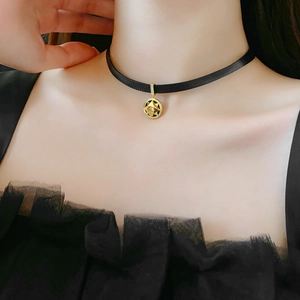 Close-up of velvet choker with gold star pendant and sparkling zircon on model