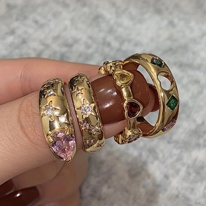 Set of four gold-plated rings with colorful heart gems and star engraving on fingers