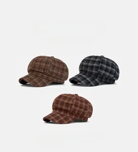 Detail view of retro plaid newsboy hats in various colors with wool fabric texture