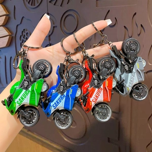 Hand holding four colors of creative motorcycle model keychains with pull-back toy feature
