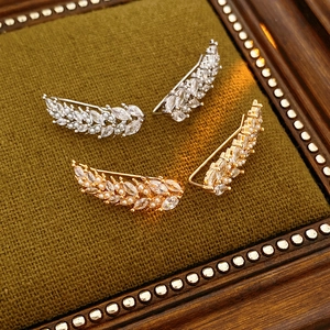 Detailed view of zircon wheat leaf and pearl ear cuffs in gold and silver finishes