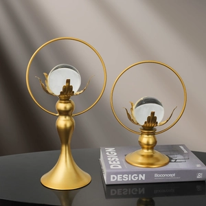 Luxe lotus crystal ball ornaments with gold metal rings on a sleek black reflective surface