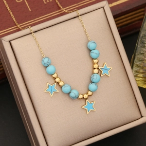 Golden star pendant necklace with blue turquoise beads displayed in a jewelry box