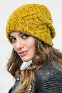 Macro shot of mustard yellow knit beanie showing geometric diamond texture and thick yarn