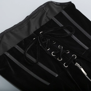 Macro detail of black velvet fabric featuring lace-up corsetry and metal zipper closure