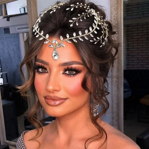 Detail of bridal forehead chain with gold vines and teardrop crystals on model
