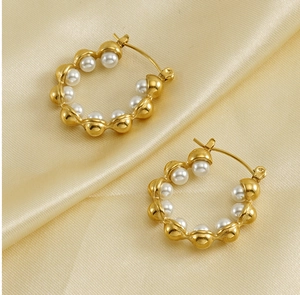 Détail de boucles d'oreilles créoles en acier titane plaqué or 18k avec perles