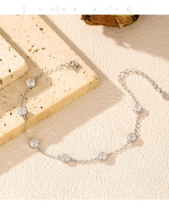 Detail of S925 silver bezel-set station bracelet on elegant beige marble decor