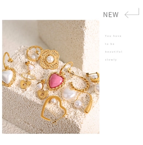 Detail of vintage gold-tone earrings with pearl and enamel accents on mineral stone