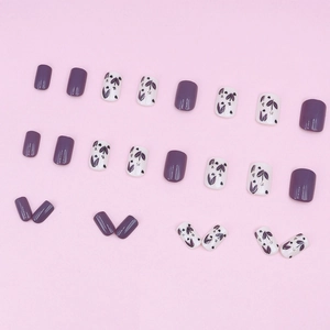 Faux ongles courts carrés lilas lavande avec motifs floraux sur fond rose pastel uni