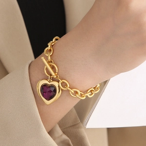 Detailed shot of a gold OT buckle bracelet featuring a large faceted purple heart crystal