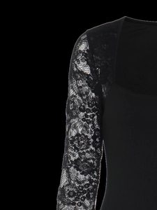 Close-up of elegant sheer floral lace sleeves and smooth fabric on a black dress