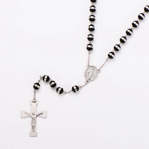 Detail of 8mm striped beads with a silver crucifix and Virgin Mary medal on the necklace