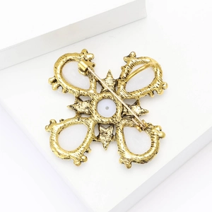 Detailed back view of golden baroque pearl brooch showing pin structure on display stand
