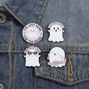Halloween ghost enamel pins set with fun slogans on a blue denim jacket pocket