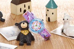 Close-up of waterproof kids watch with unicorn strap and colorful rainbow dial numbers