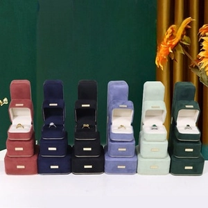 Velvet jewelry boxes with metal labels in various colors for rings and necklaces