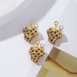 Detailed view of three 18K gold-plated strawberry charms with purple cubic zirconia