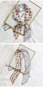 Detail of double-sided silk ribbon scarf with abstract face print and colorful patterns
